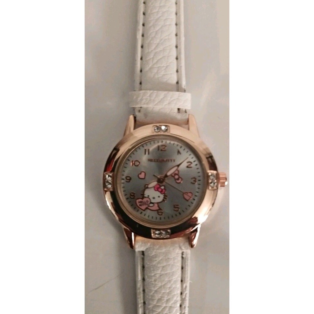 Hello Kitty watch features a metallic dial and a white faux leather strap.